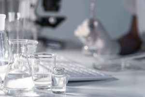 close-up-blurry-researcher-holding-glassware